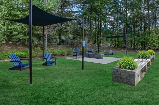 Outdoor seating area with Adirondack chairs and a fire pit.