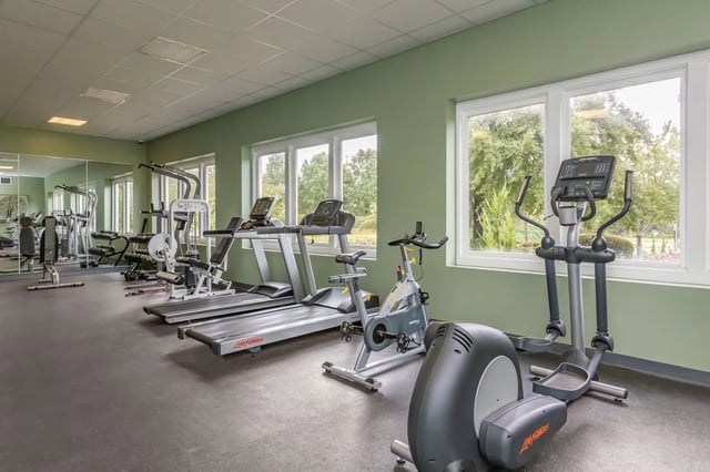 Gym with treadmills, elliptical, exercise bike, and weight machines.