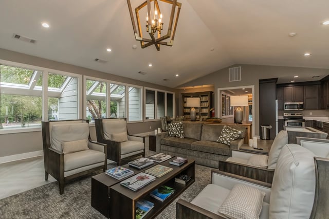 Spacious community lounge area with comfortable seating and a modern chandelier.