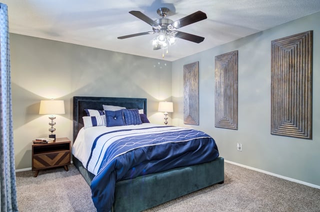 Primary bedroom with king-size bed, ceiling fan, and modern decor.