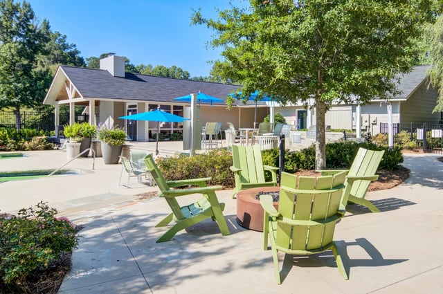 Outdoor seating area with fire pit and pool view.