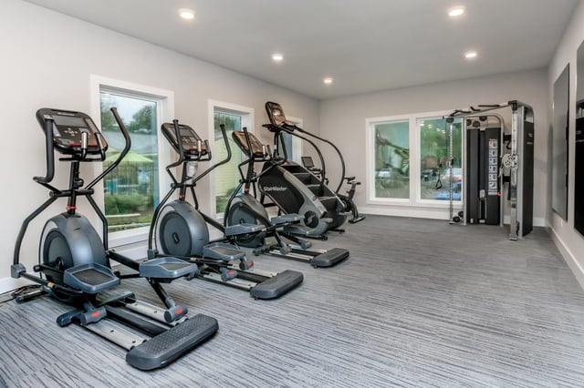 Elliptical machines, stair climber, and weight machine in a modern gym.