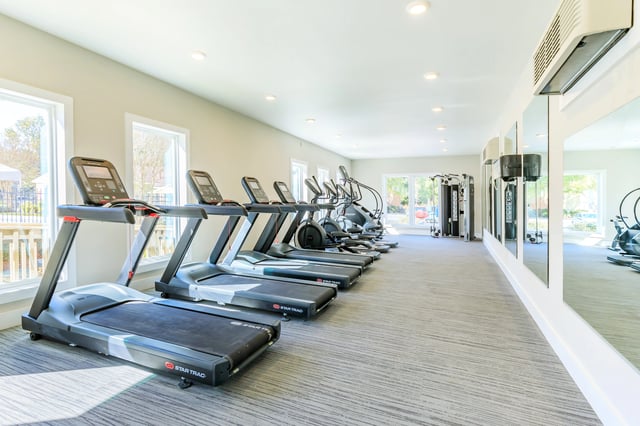 Treadmills and exercise machines in a well-lit fitness center.