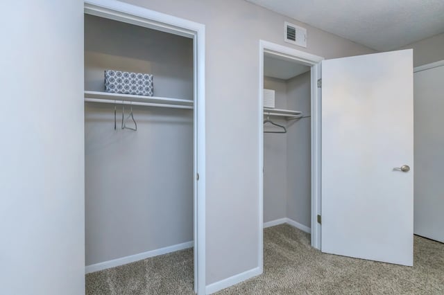 Two empty closets with shelving and hanging rods.