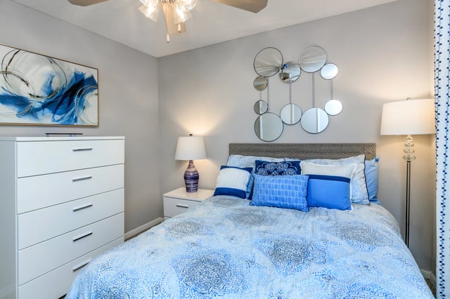 Cozy bedroom with a queen-size bed, dresser, and bedside table.