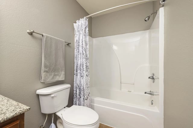 Clean bathroom with a toilet, shower, and bathtub.