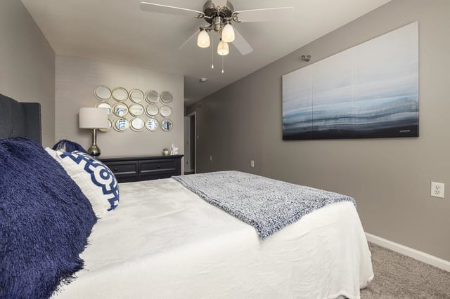 Bedroom with a bed, dresser, and artwork.