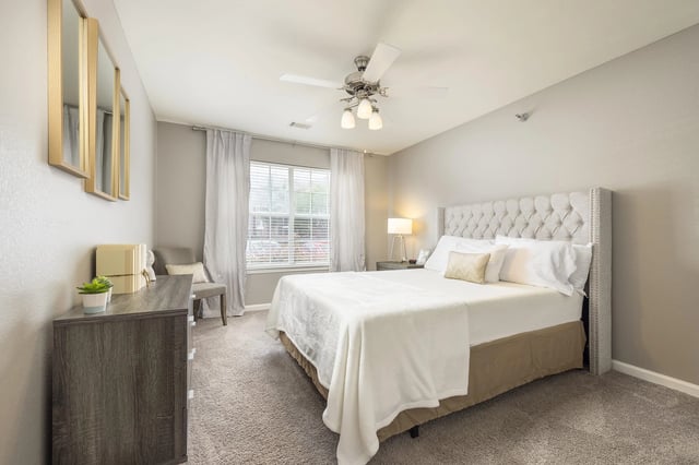 Bedroom with a king-sized bed, dresser, and window.