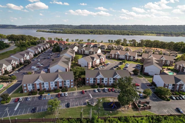 Aerial view of apartment buildings with a lake in the background.