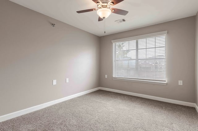 Bedroom with neutral carpet, ceiling fan, and large window with blinds.