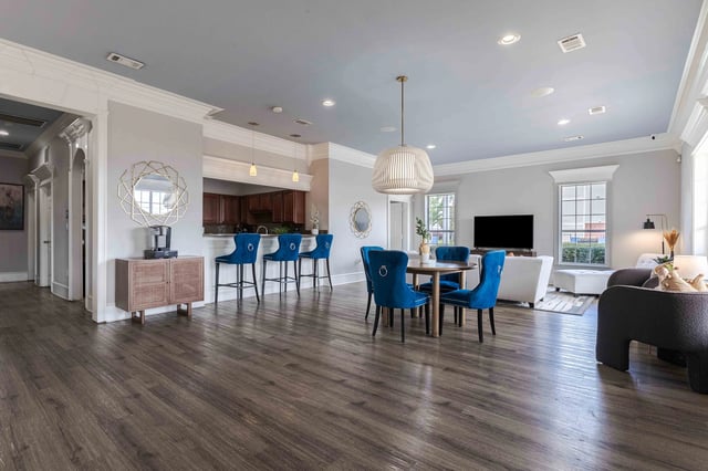 Open concept common area with a kitchen island, bar seating, and a dining table.