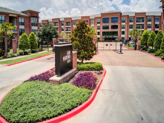 San Marino apartment complex entrance with monument sign and gated driveway.