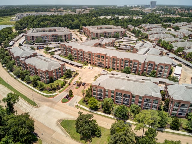 Aerial view of apartment buildings and surrounding grounds.