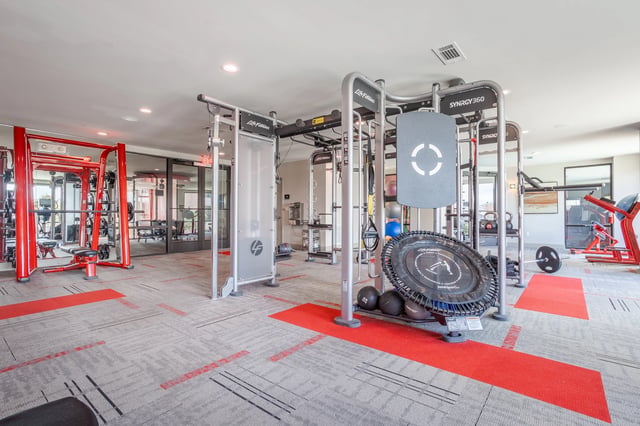 Modern fitness center with various strength training and cardio equipment.