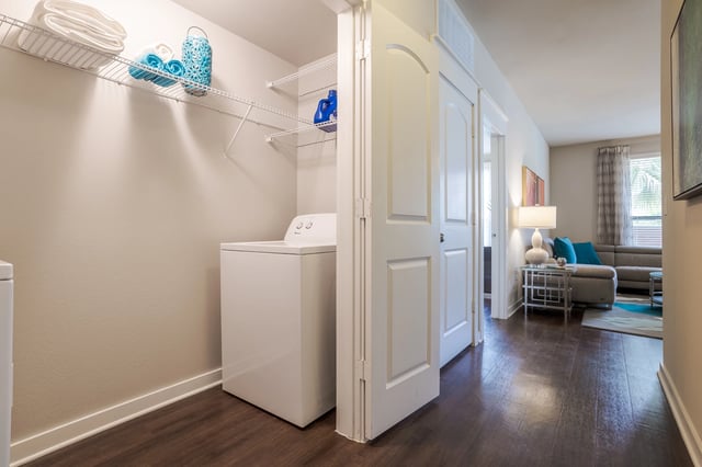 Washer and dryer in laundry closet with shelves above.
