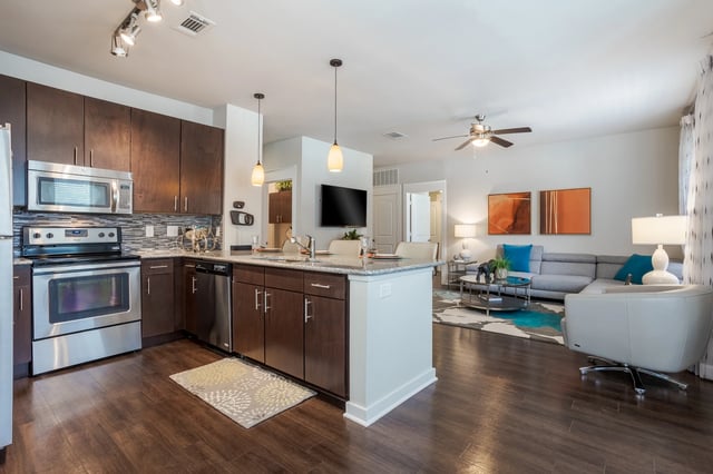Modern kitchen and living room with island and sectional sofa.
