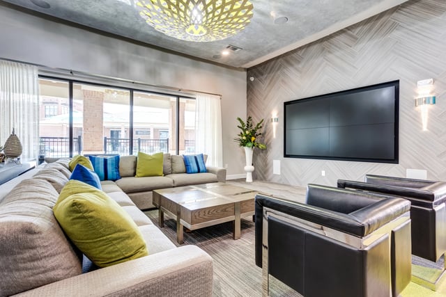 Stylish lounge area with large sectional sofa, coffee table, and large screen TV.