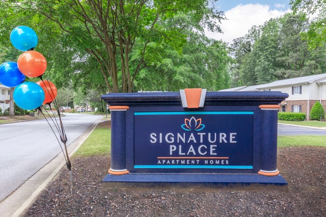 Signature Place Apartment Homes monument sign with balloons.
