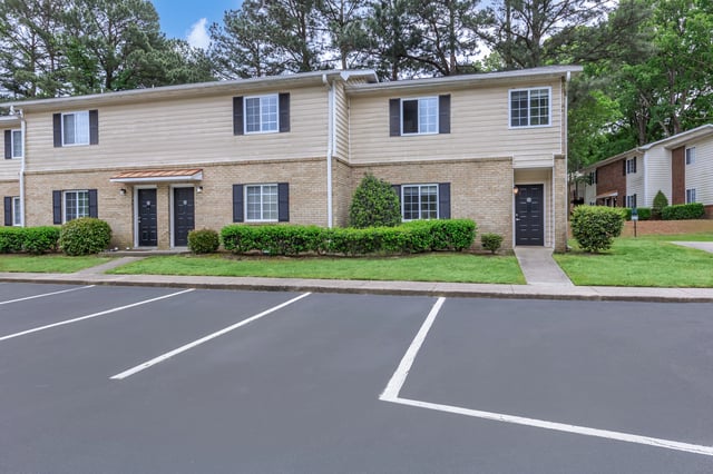 Apartment building exterior with parking lot in foreground
