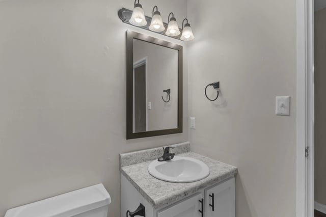 Bathroom vanity with sink, mirror, and towel rack.