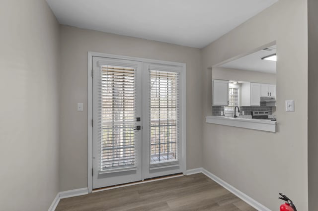 View of a dining area with double doors and a pass-through to the kitchen.