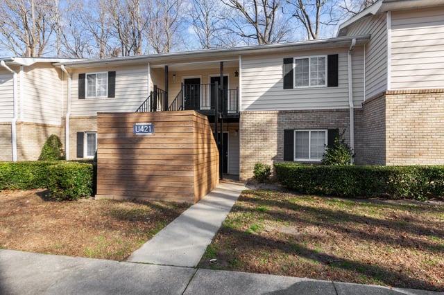 Exterior of apartment building U421 with wood paneling and brick accents.