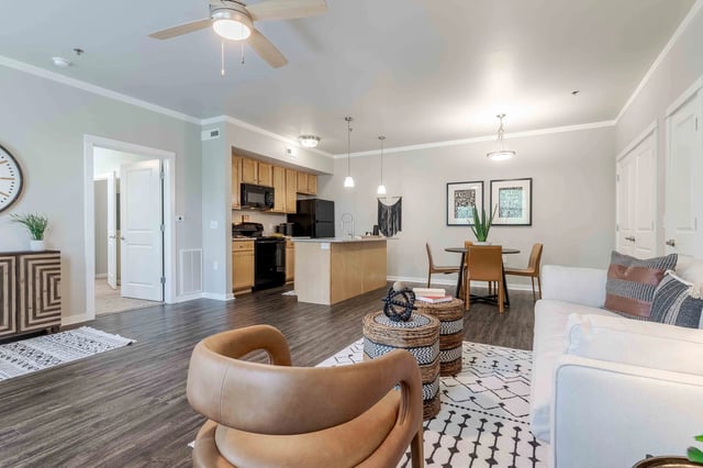 Open concept living and kitchen area with island, dining table, and sofa.