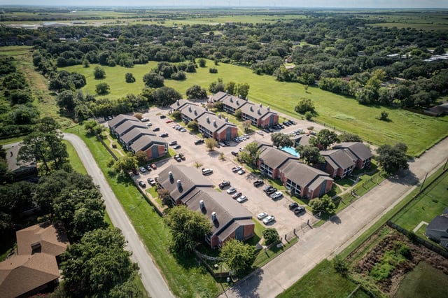 Aerial view of apartment buildings and a swimming pool.
