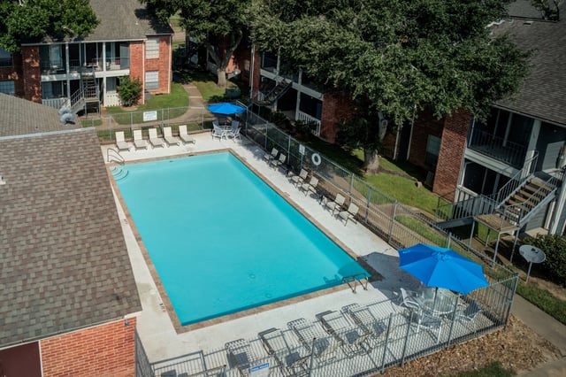 Aerial view of an outdoor swimming pool with lounge chairs and umbrellas