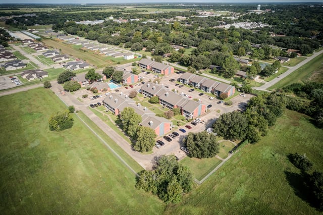 Aerial view of apartment buildings and a swimming pool.