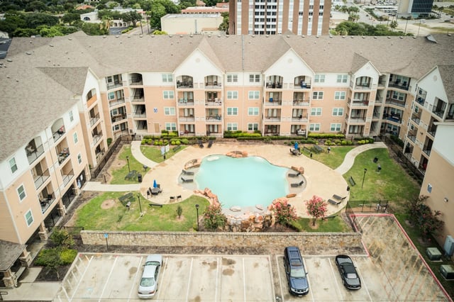 Aerial view of a swimming pool and apartment buildings.