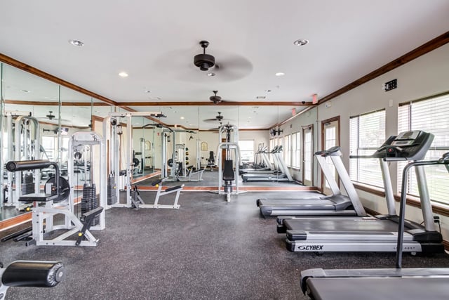 Fitness center with treadmills, weight machines, and mirrors.