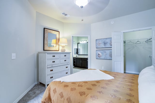 Bedroom with a dresser, mirror, and open closet
