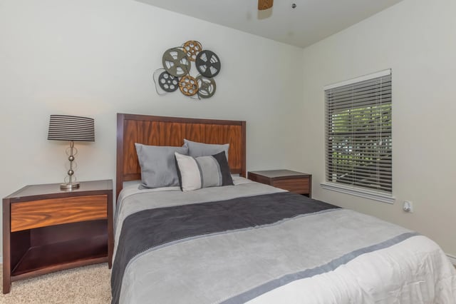 Bedroom with a queen-size bed, nightstands, and a window.
