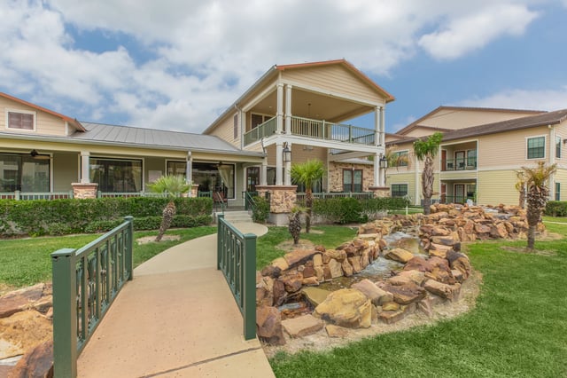 Apartment building exterior with a decorative water feature and walkway.