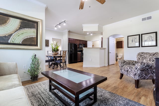 Living room with a coffee table, dining area, and kitchen visible.