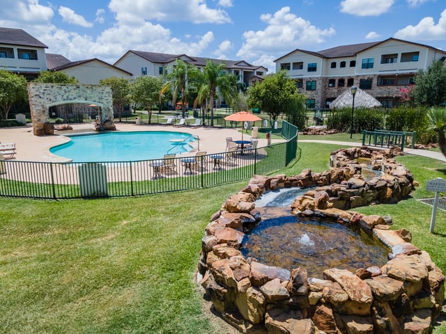 Luxury swimming pool and water feature at apartment complex.