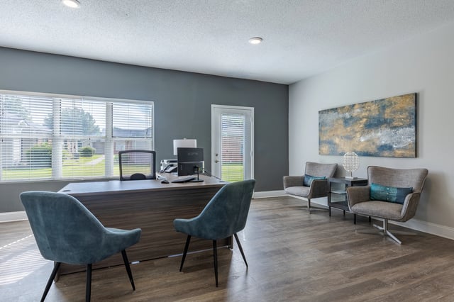 Office reception desk with chairs and artwork.