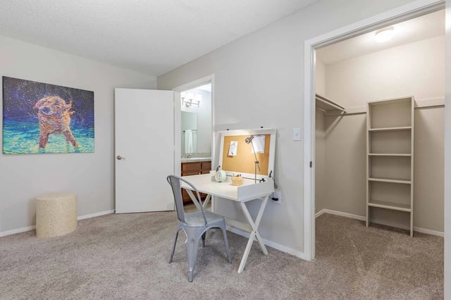 Bedroom with a desk and chair, a closet, and a painting of a dog.