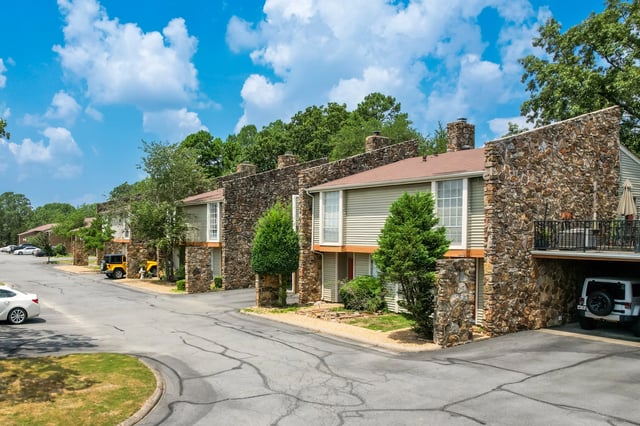 Exterior view of apartment buildings with stone accents and balconies.