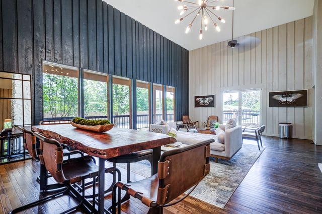 Modern dining area with a live-edge wood table and leather chairs, adjacent to a living room.