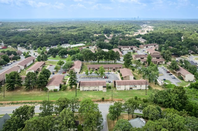 Aerial view of apartment buildings surrounded by trees and greenery.