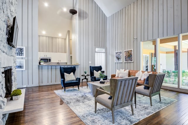 Spacious living room with vaulted ceilings, a fireplace, and an open-concept kitchen.