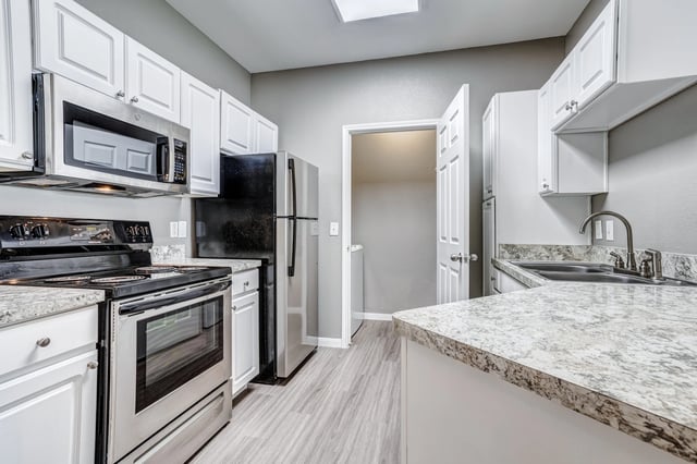 Modern kitchen with stainless steel appliances and granite countertops.