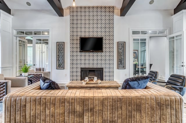 Modern living area with a large sectional sofa, fireplace, and TV.
