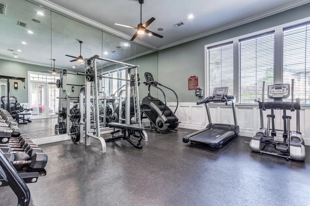Fitness center with weight machines, treadmills, and elliptical trainers.
