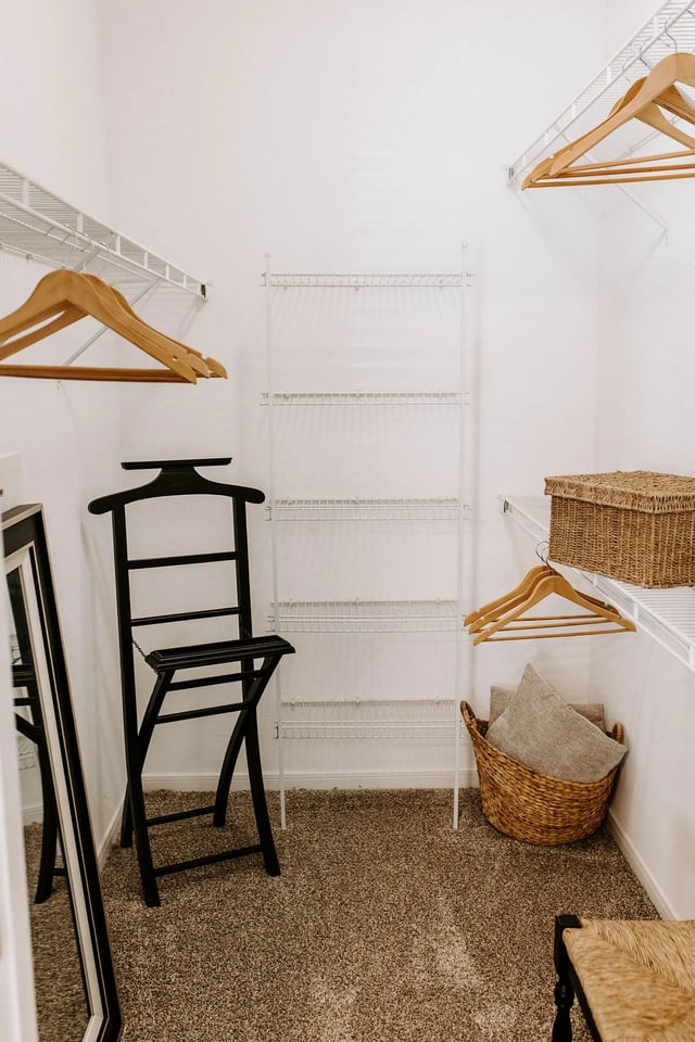 Walk-in closet with shelving, hangers, and valet stand.