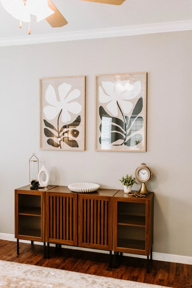 Modern buffet table with abstract floral art and a vintage clock.