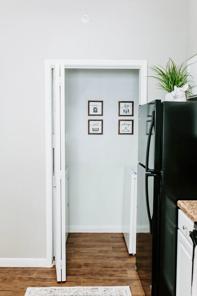 Interior view of a laundry closet with washer and dryer in a multifamily apartment.