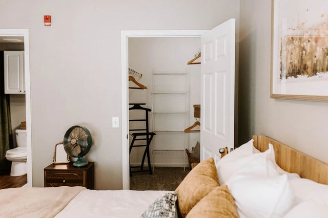 Bedroom with open closet and view of toilet